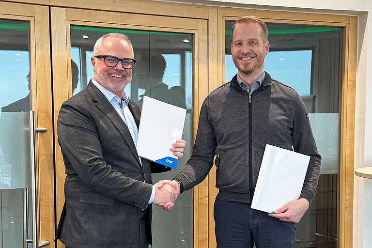 Robert Angel von SMC und und Markus Zebisch von HENNLICH Global bei der Vertragsunterzeichnung in Suben.